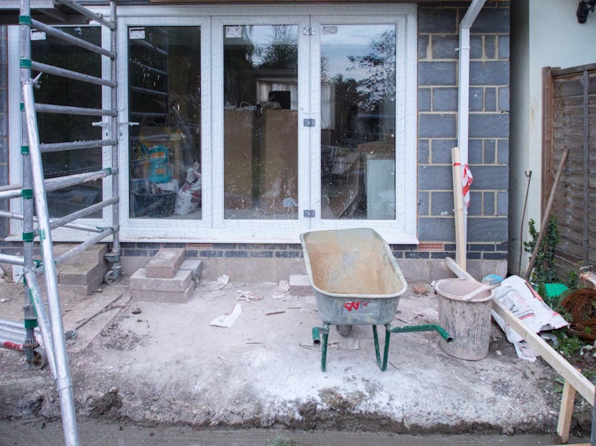 A large pile of construction and demolition debris is accumulated on an outdoor flat roof or terrace area of a multi-storey building, including broken concrete blocks, pieces of plasterboard, fragment